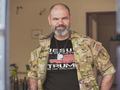 Man wearing camo jacket and Christ My Savior Trump My Guide graphic tee, showing pride in his values.