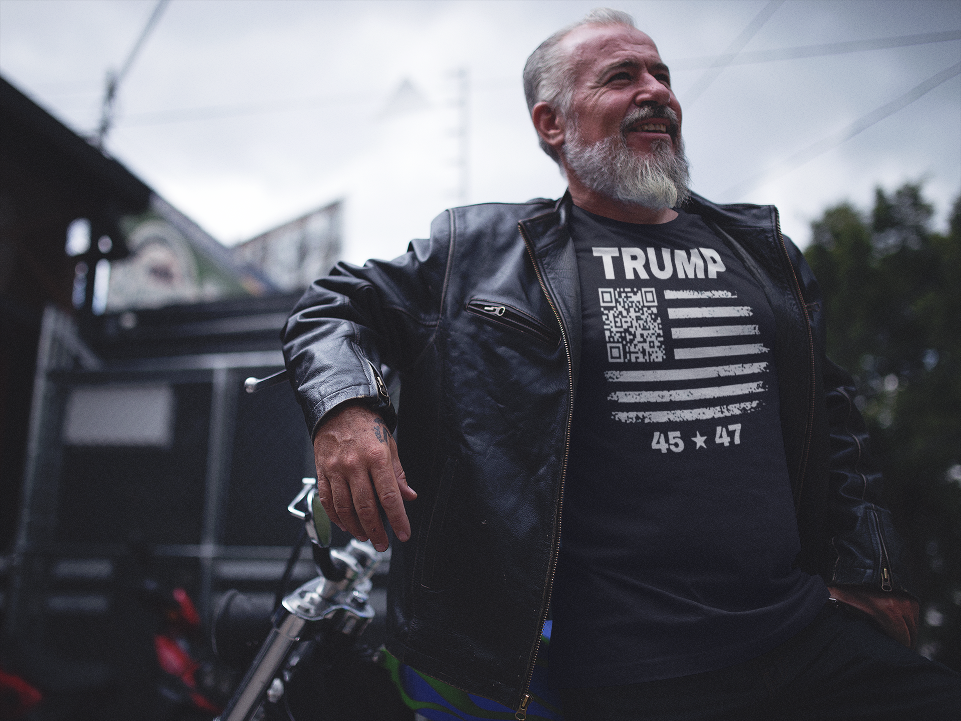 Man wearing a leather jacket and Presidential 45 47 Trump Series graphic tee, posing confidently outdoors.