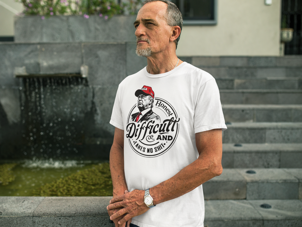 Man wearing True Tough Takes No Shit Design graphic tee, standing by a water feature.