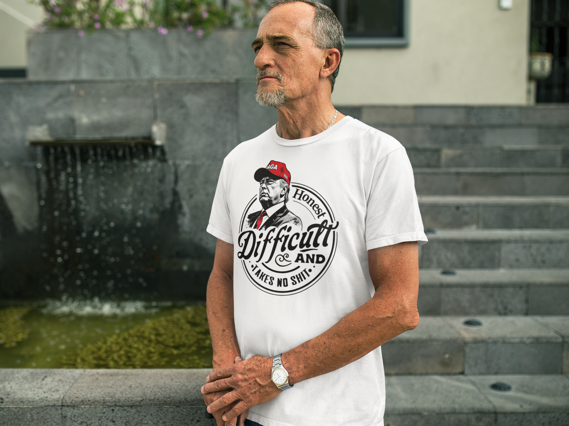 Man wearing True Tough Takes No Shit Design graphic tee, standing by a water feature.