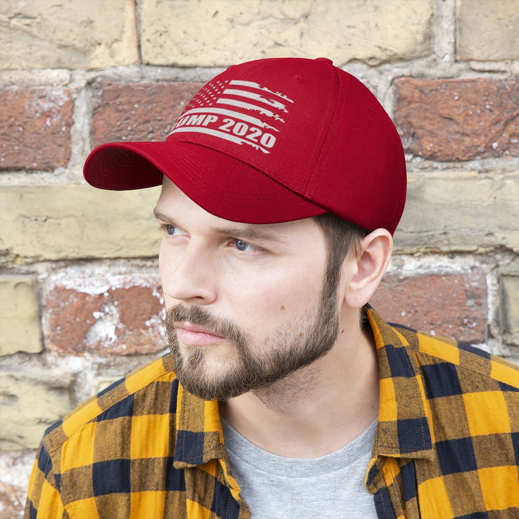 Man wearing a Trump 2020 Distressed American Flag Wht Ltrs Twill Cap in red, styled with a plaid shirt.