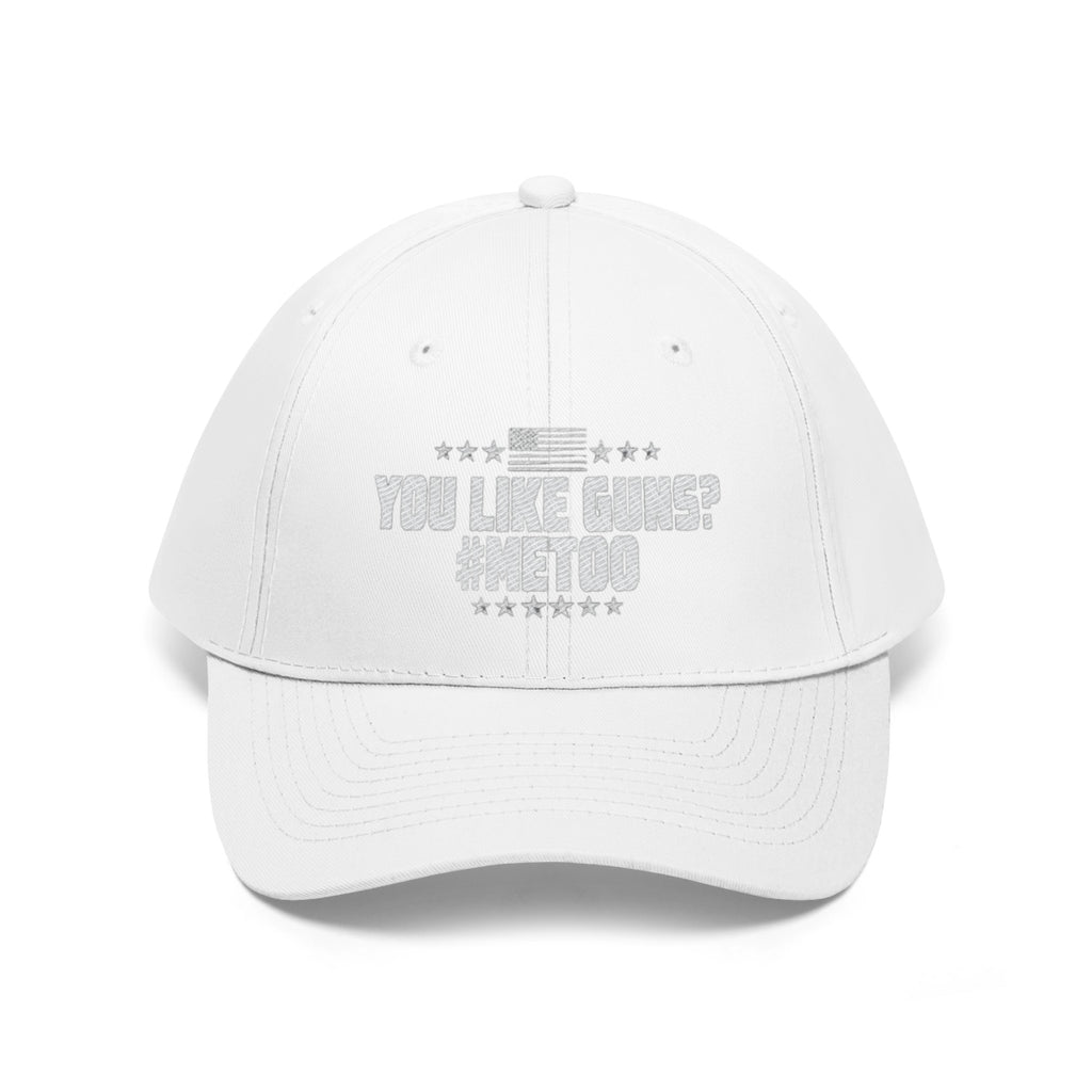 You Like Guns Me Too Twill Cap featuring bold text and patriotic design on a white dad hat.