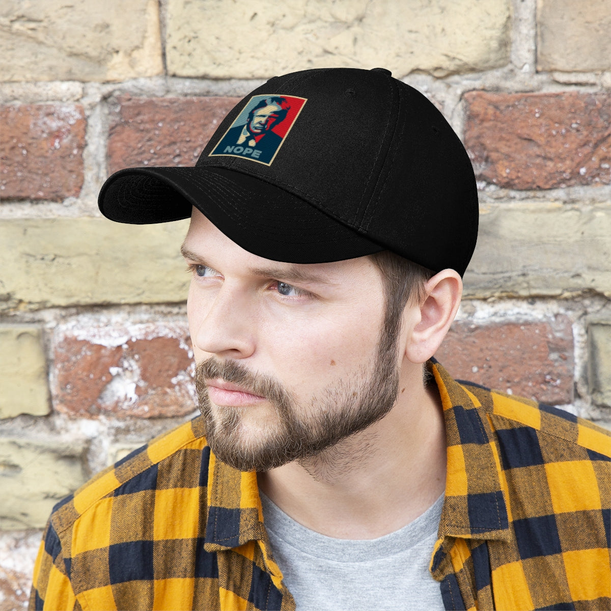 Vintage Nope Baseball Cap Inspired by Trump worn by a man in a plaid shirt against a brick wall.