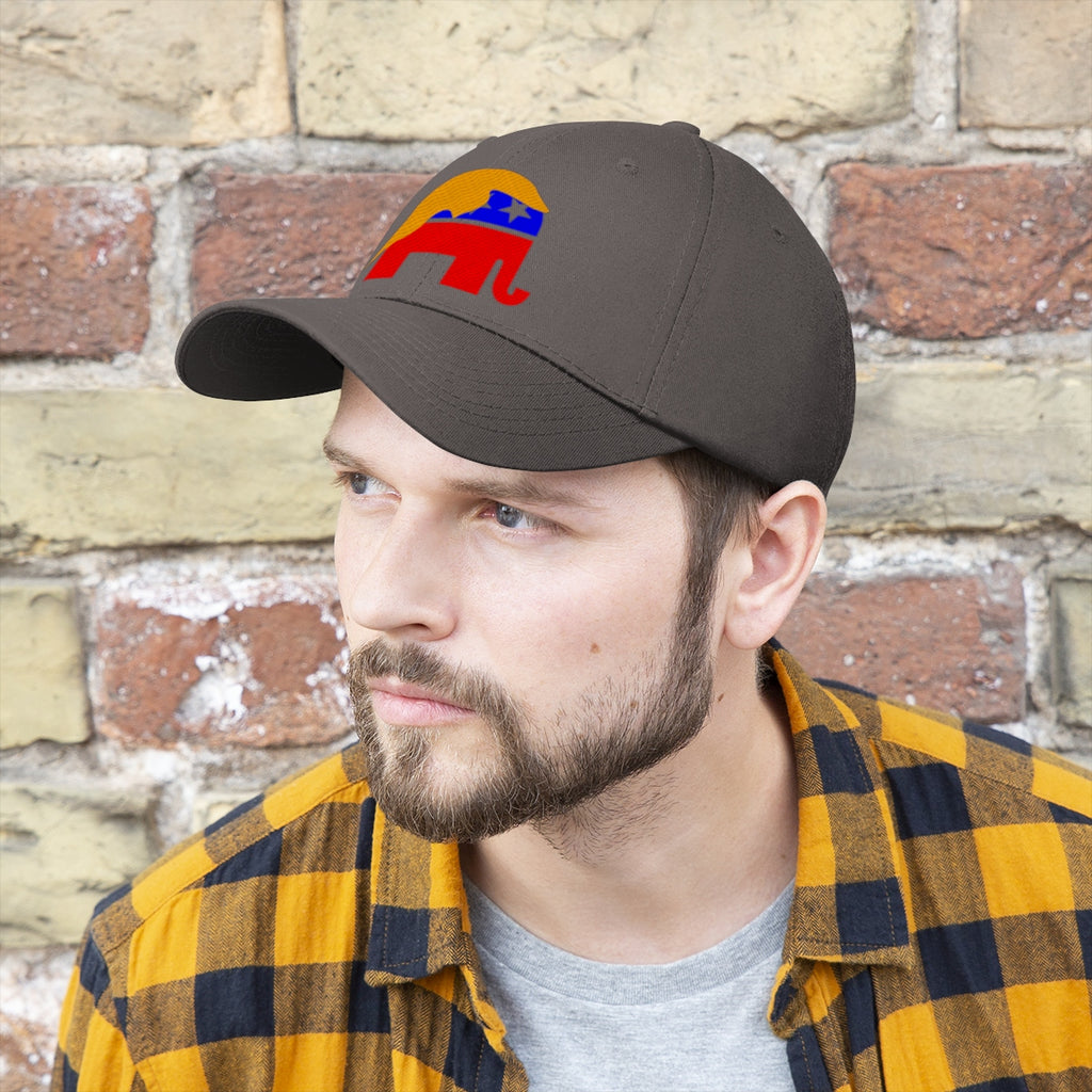 GOP Symbol With Trump Hair Twill Cap worn by a man against a brick wall background.