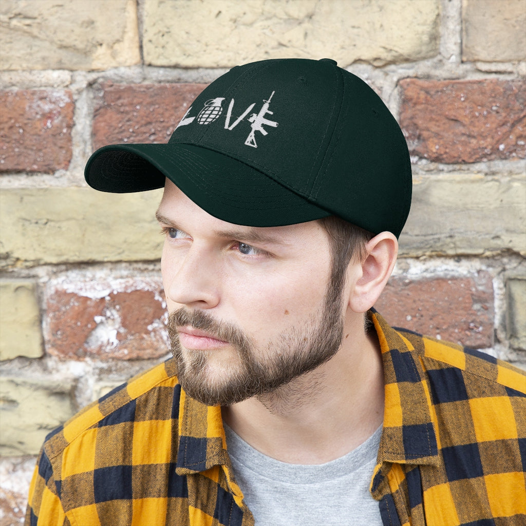 Love Combat Inspired Street Style Twill Cap worn by man with beard and plaid shirt against brick wall.