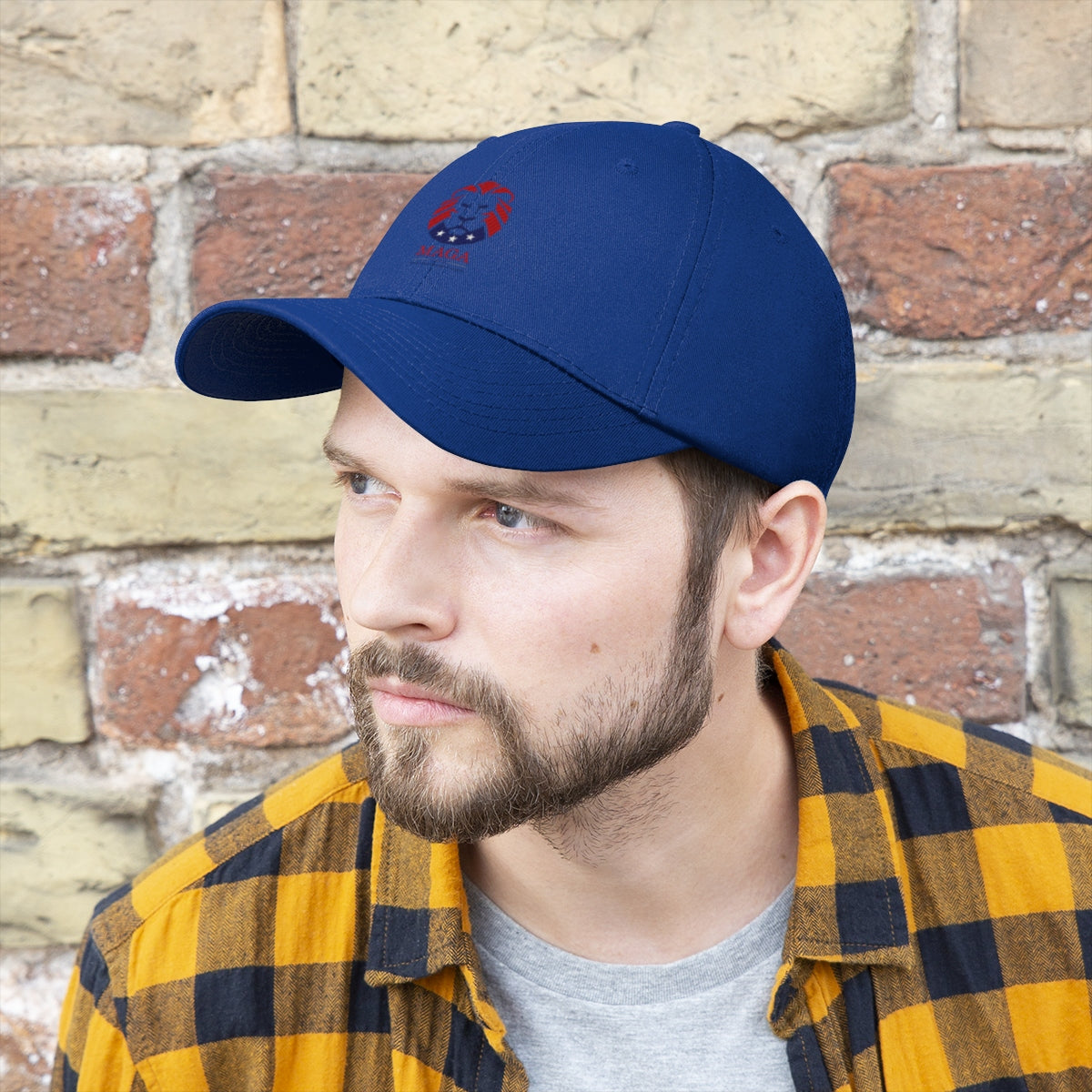 MAGA Lion Embroidered Cotton Twill Cap Design worn by a man in a checkerboard shirt, set against a brick wall.
