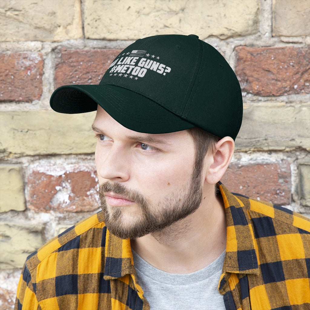 Man wearing You Like Guns Me Too Twill Cap against a brick wall, showcasing bold personal philosophy.