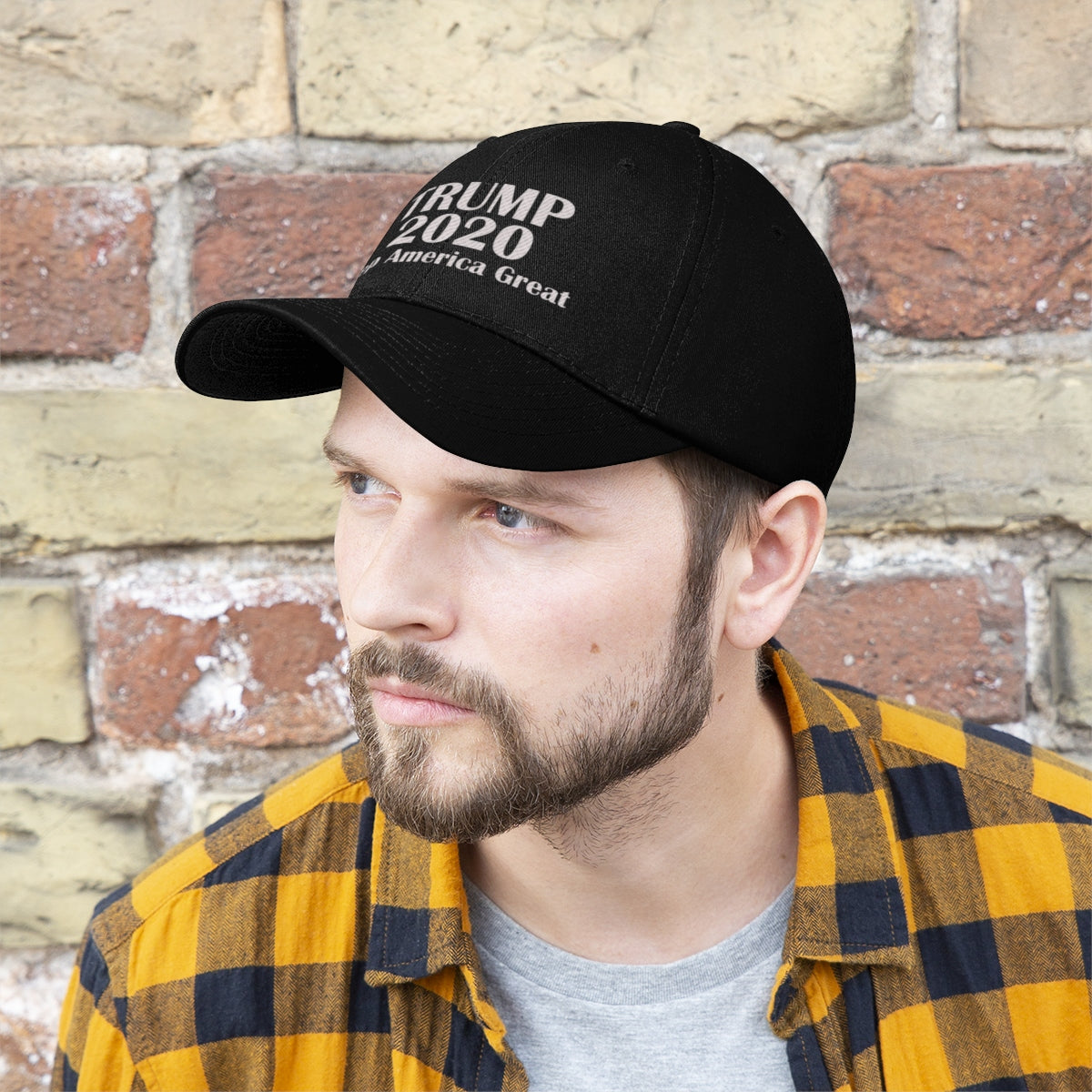 Trump 2020 Keep America Great Campaign Twill Cap worn by a man against a brick wall.