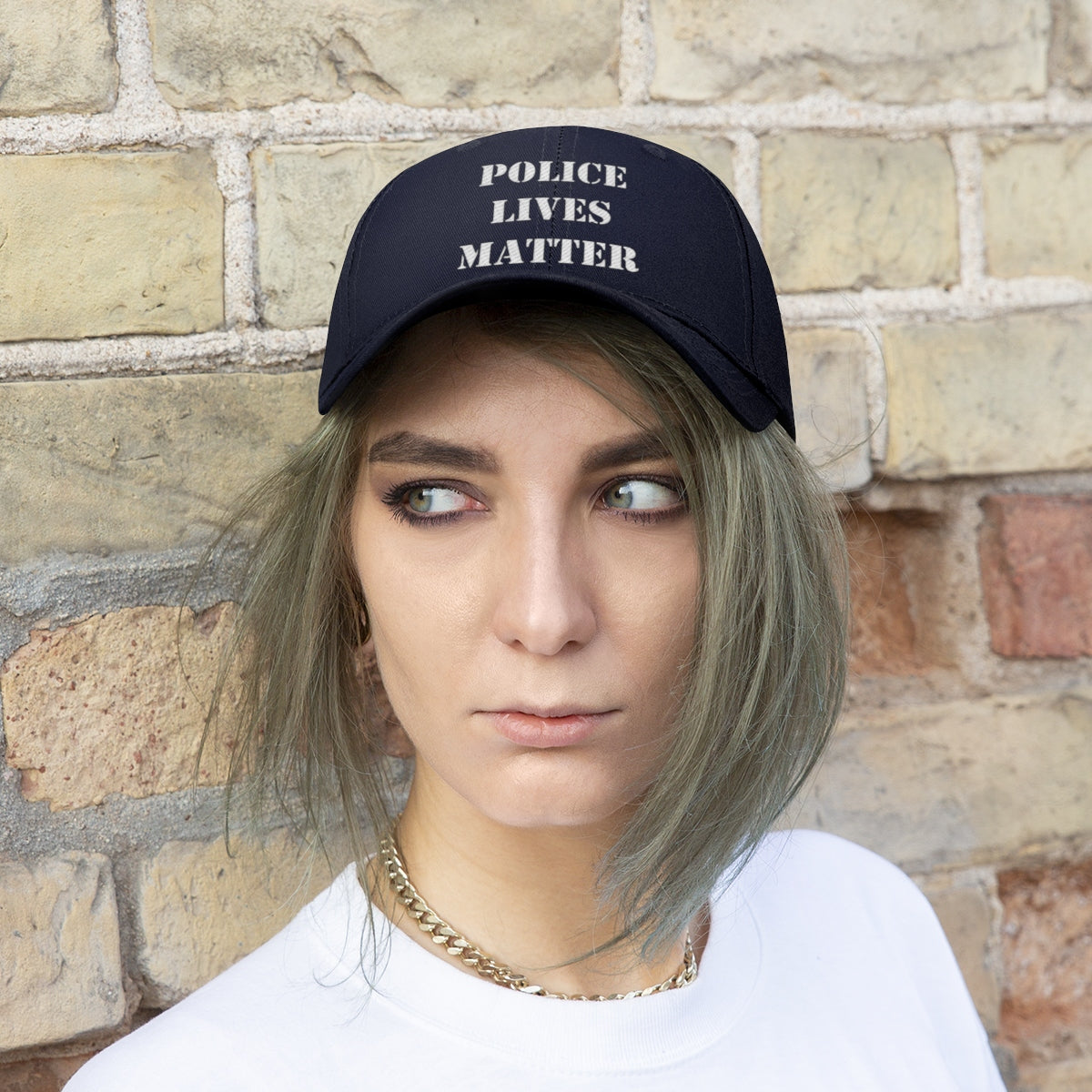 Model wearing an Embroidered Police Lives Matter Twill Cap against a brick wall backdrop.