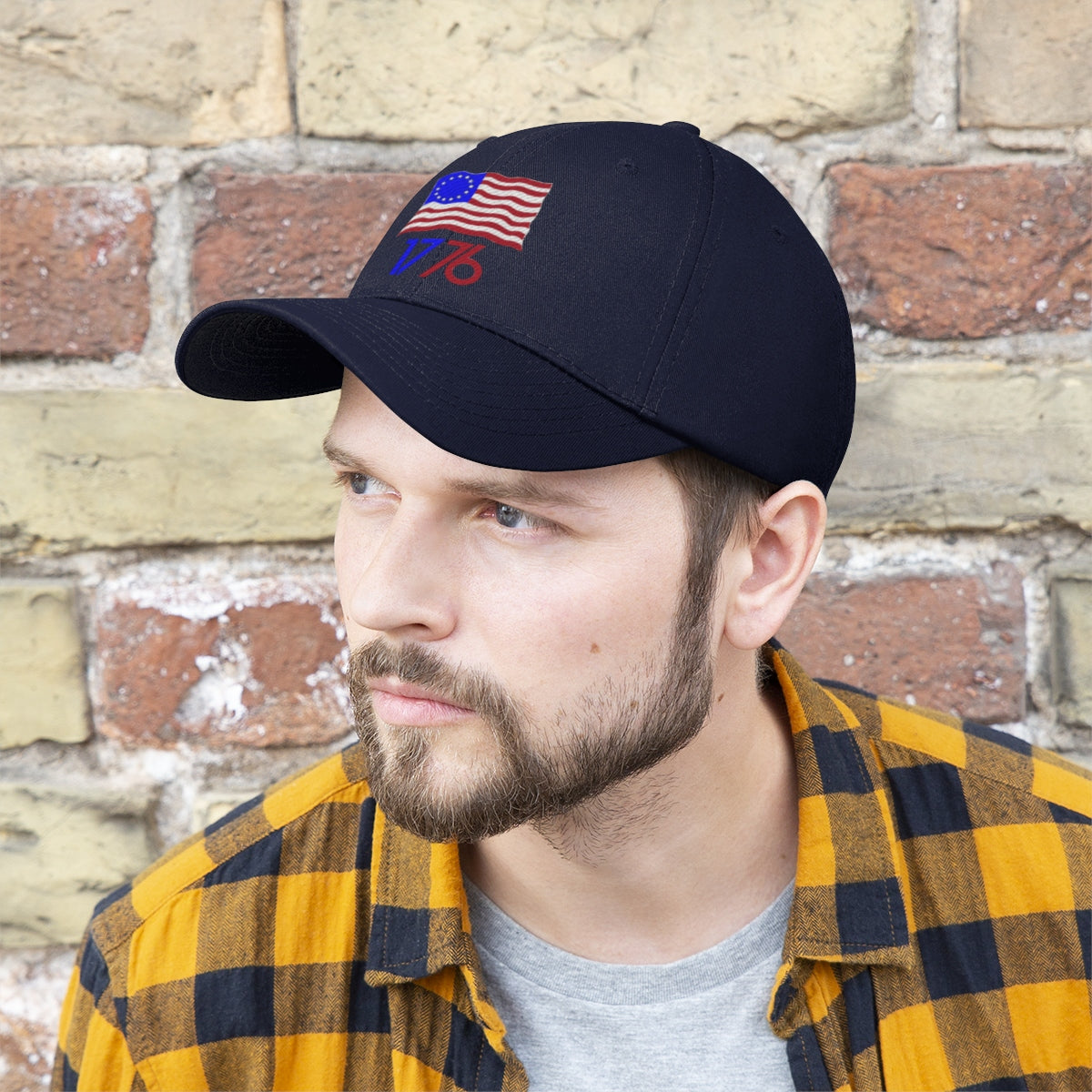 Man wearing Betsy Ross Flag 1776 Twill Cap in front of a brick wall.