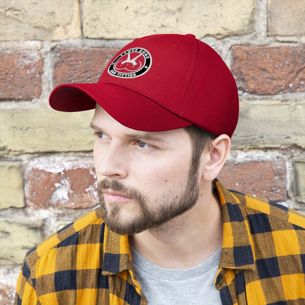 Man wearing I Love Guns And Titties Twill Cap, showcasing a defiant style against a brick wall background.