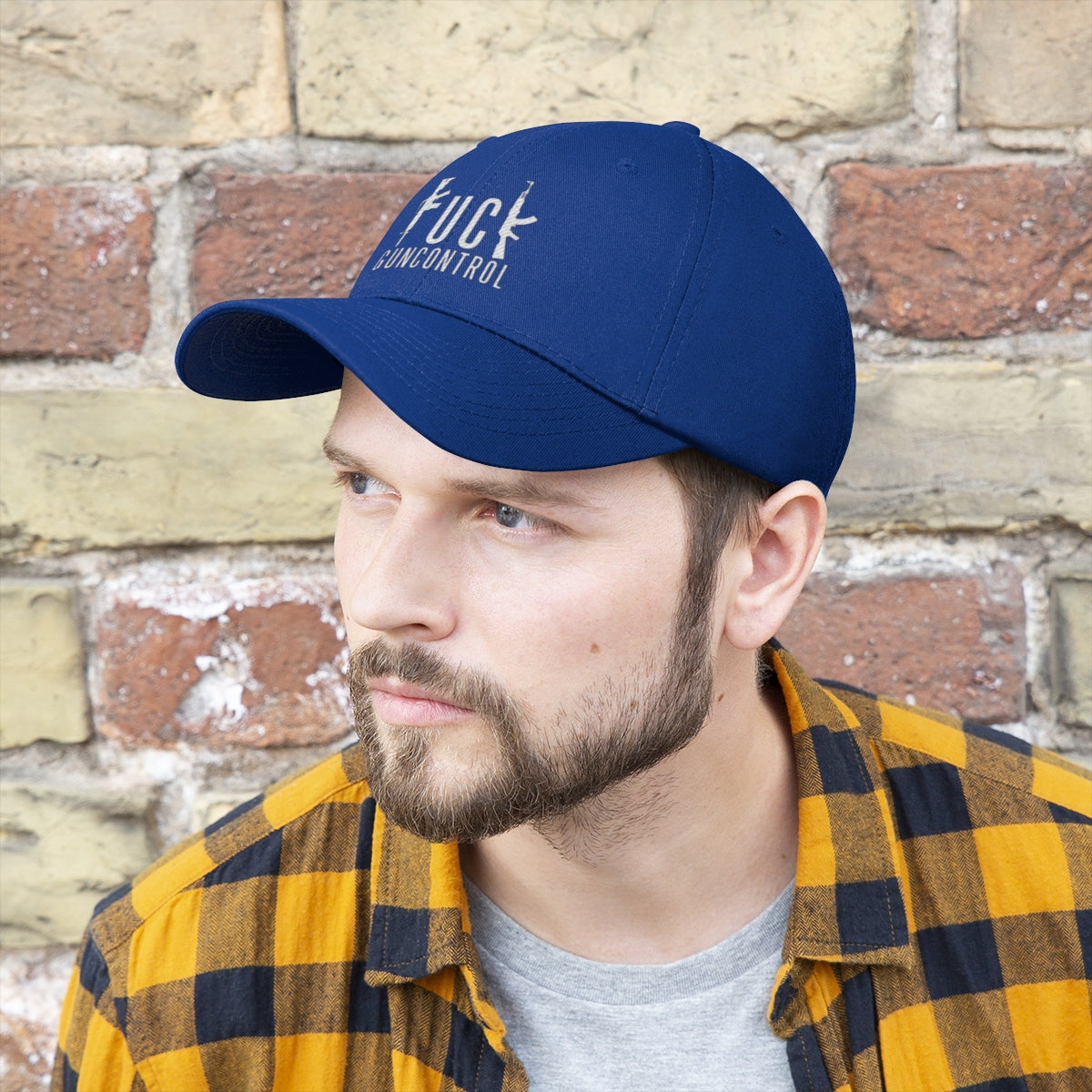 Vintage Fuck Gun Control Cotton Twill Cap worn by a man with a beard, set against a brick wall.