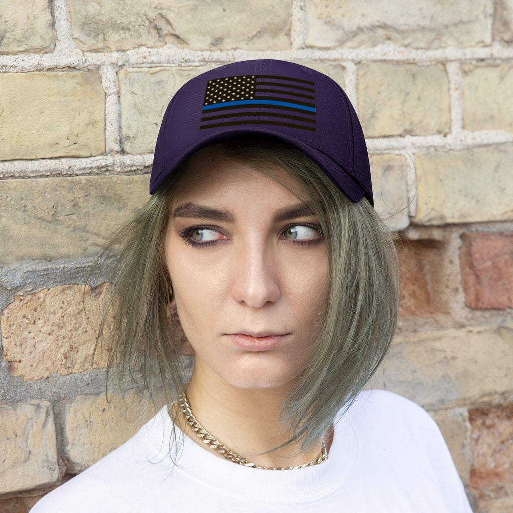 Thin Blue Line American Flag Twill Cap worn by a woman against a brick wall background.