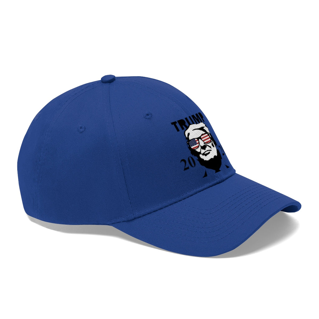 Trump 2020 With US Flag Glasses Twill Cap displayed on a blue cap featuring a bold design.