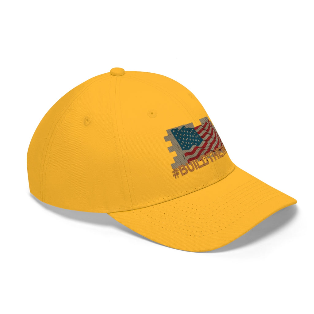 Build The Wall On American Flag Twill Cap with American flag design on a yellow background.