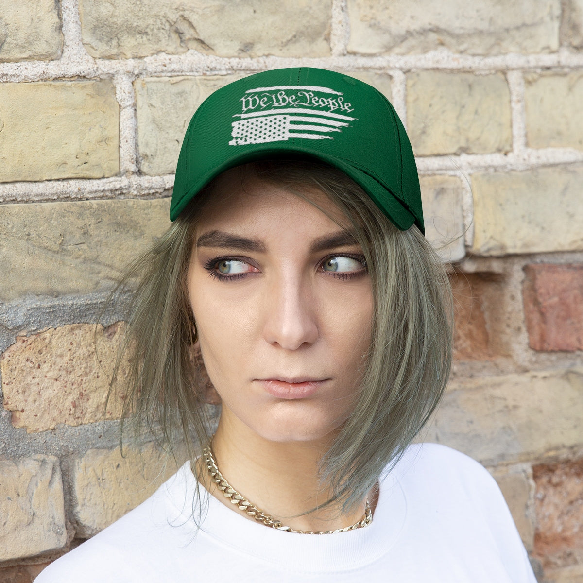 We The People On Distressed American Flag Twill Cap featured on a model against a brick wall.