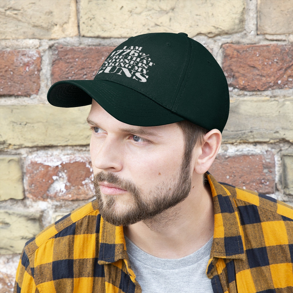 Man wearing I Am 1776 Sure That No One Is Taking My Guns Twill Cap against a brick wall.