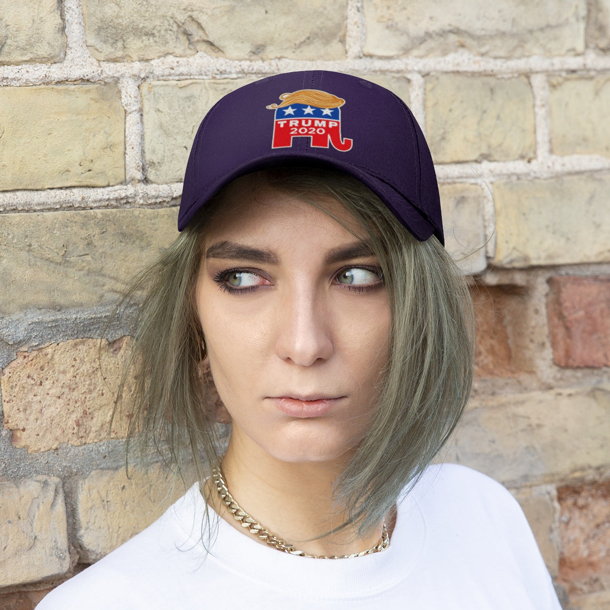 Model wearing Hair 2020 Twill Baseball Cap Featuring Trump against a brick wall.