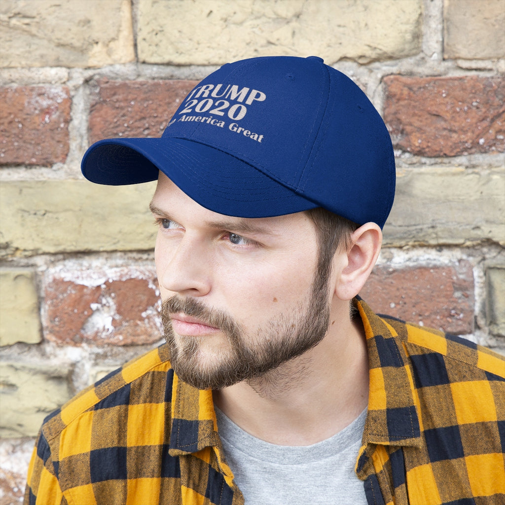 Man wearing Trump 2020 Keep America Great Campaign Twill Cap against a brick wall.