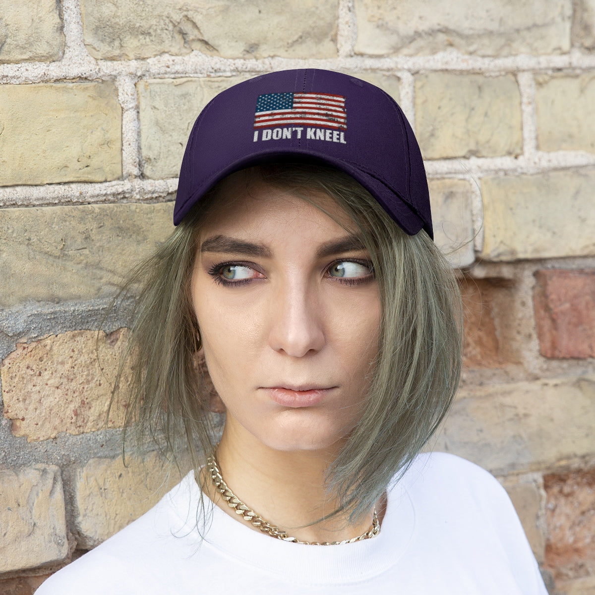 I Don't Kneel American Flag Twill Cap worn by a model in front of a brick wall, showcasing its patriotic design.