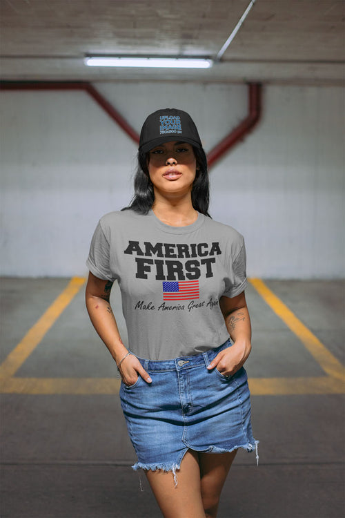 Woman wearing 'America First Make America Great Again' t-shirt in urban setting, supporting conservative message and style.