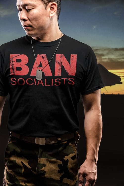 Man wearing Ban Socialists Bold Statement Casual Wear Tee Shirt with camouflage pants, evening backdrop