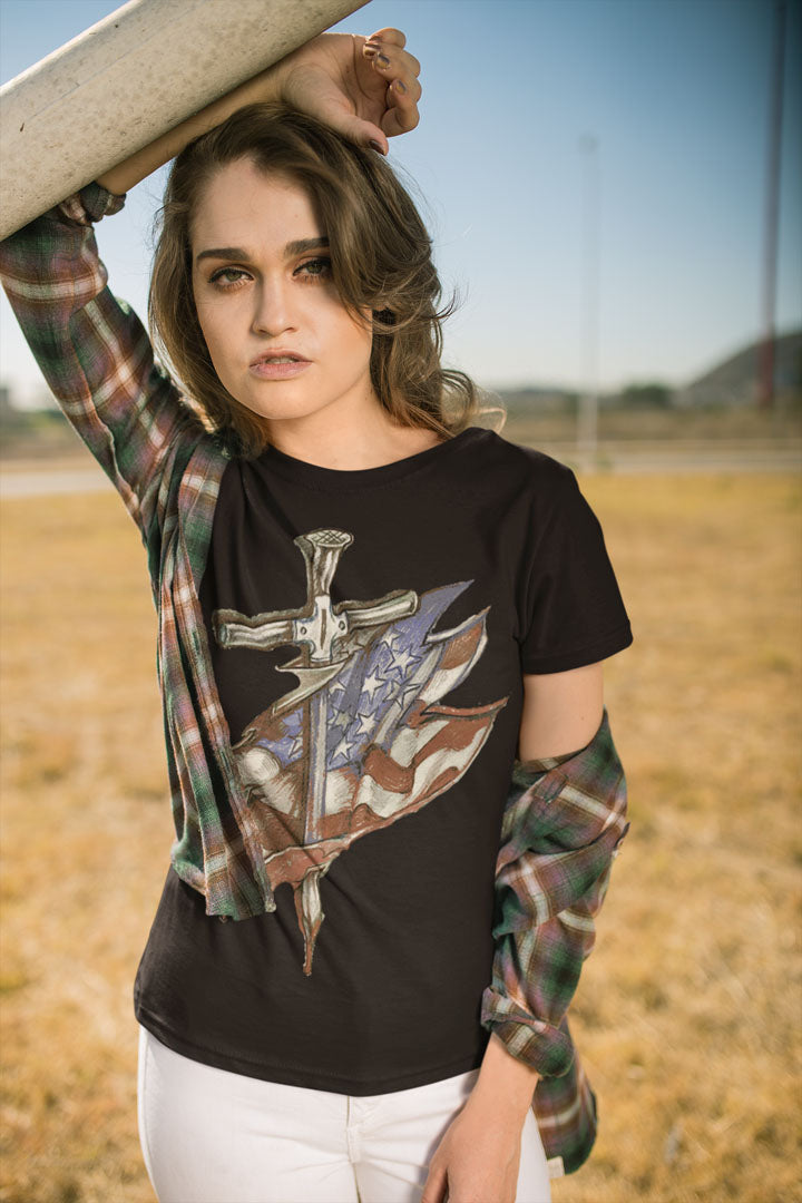 Model wearing a Dagger and American Flag Graphic Tee, showcasing an edgy blend of patriotic and martial aesthetics in outdoor setting.