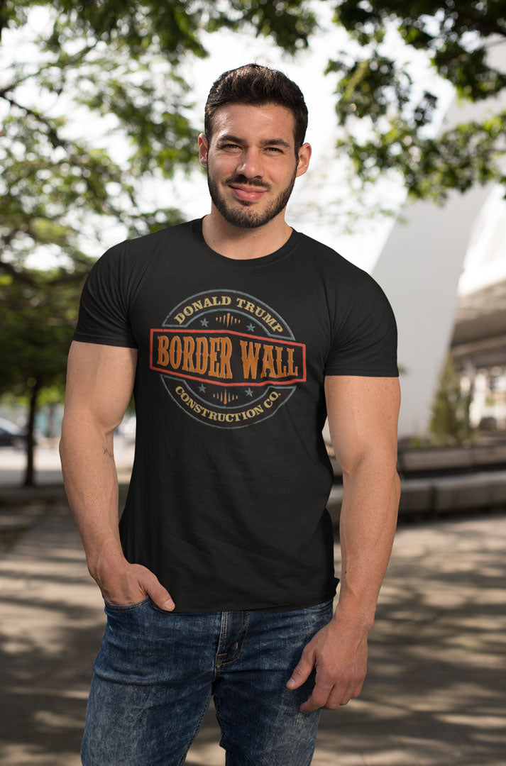 Man wearing Border Wall Graphic Statement Tee standing outdoors