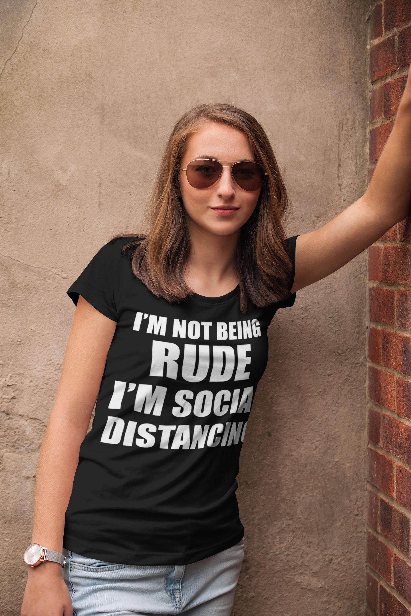 Woman wearing I'm Not Being Rude I'm Social Distancing shirt, standing against a wall, casual streetwear fashion.