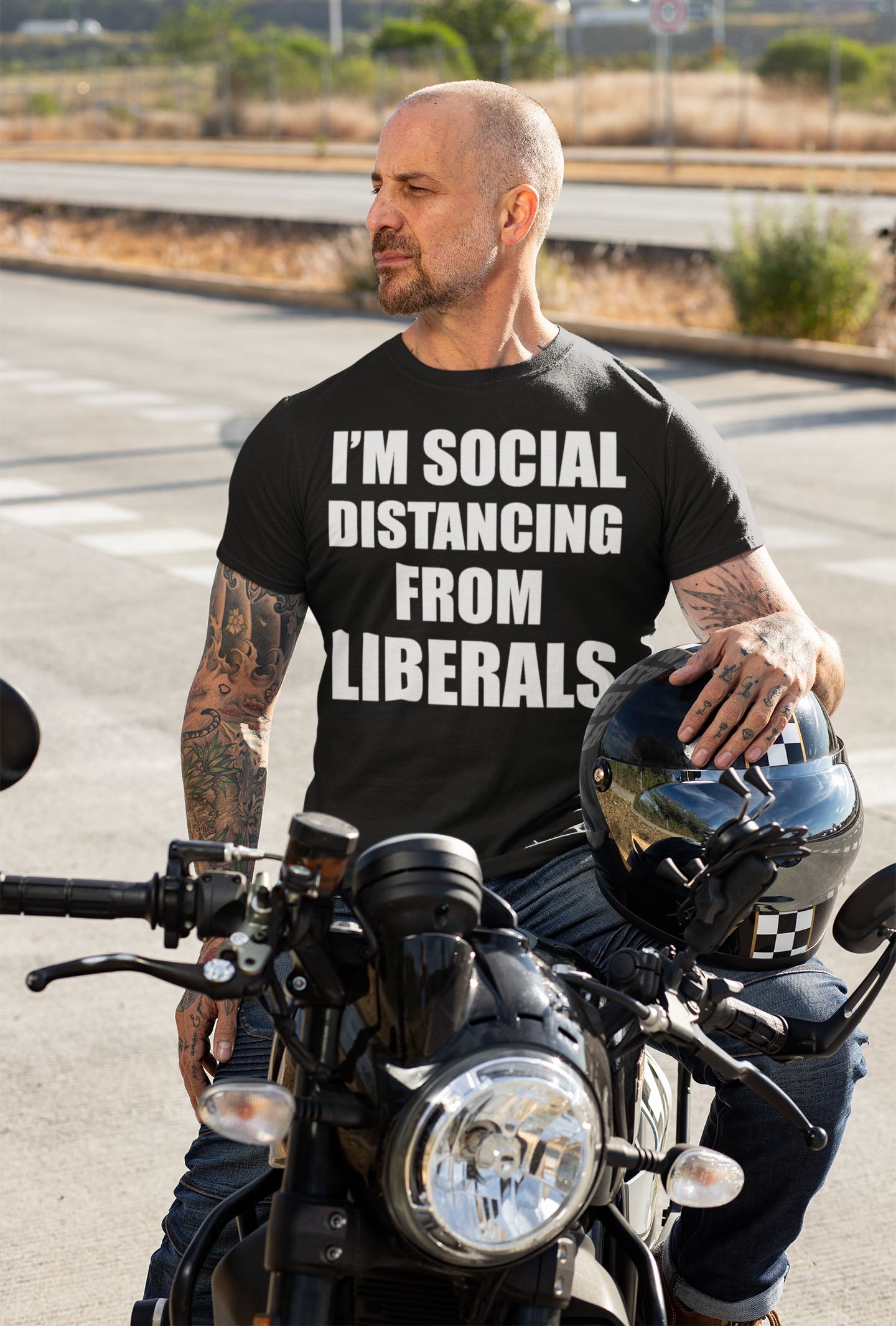 Man wearing 'I'm Social Distancing From Liberals' t-shirt sitting on motorcycle