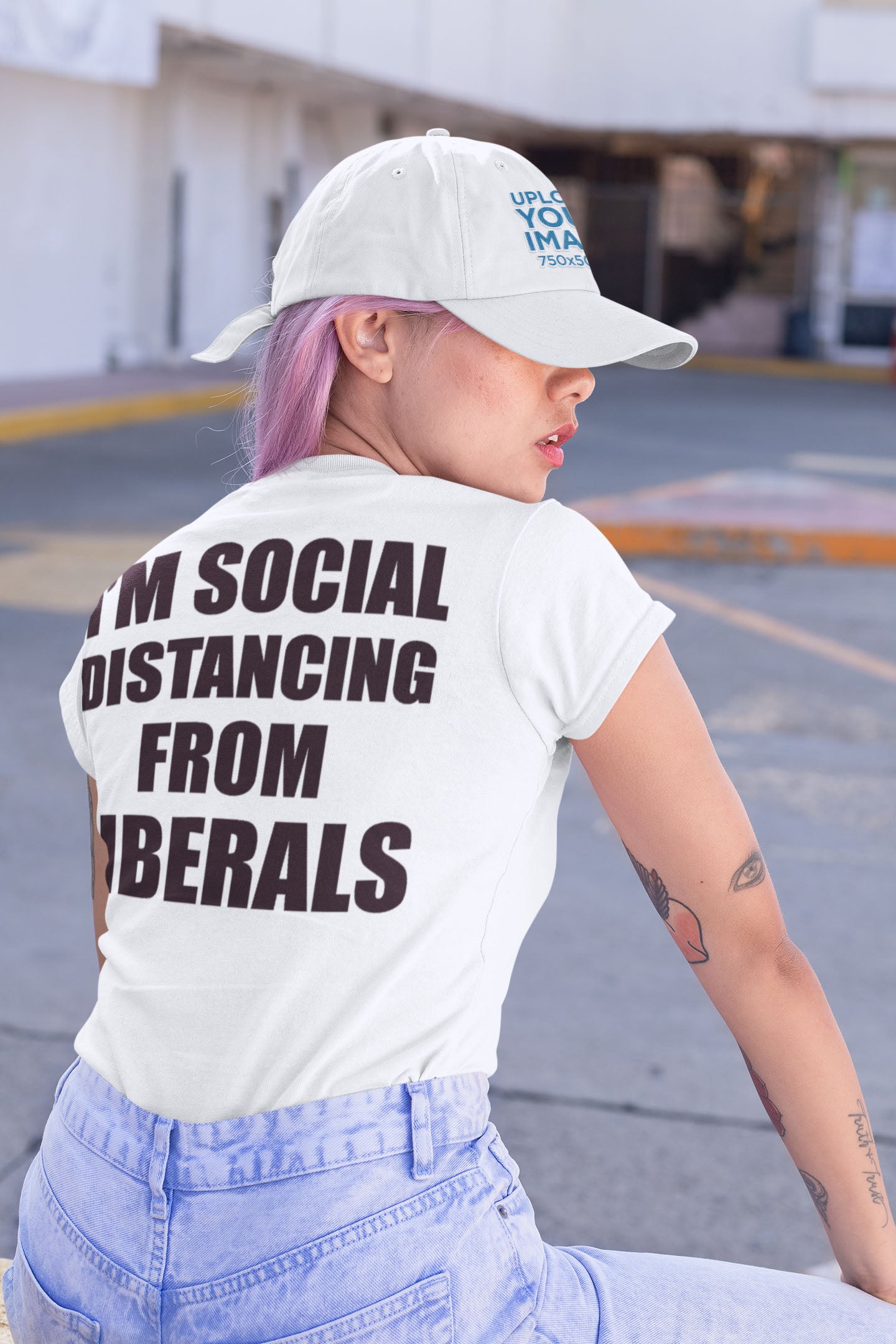 Person wearing Social Distancing From Liberals White Text Back Cap and matching shirt, sitting outdoors.