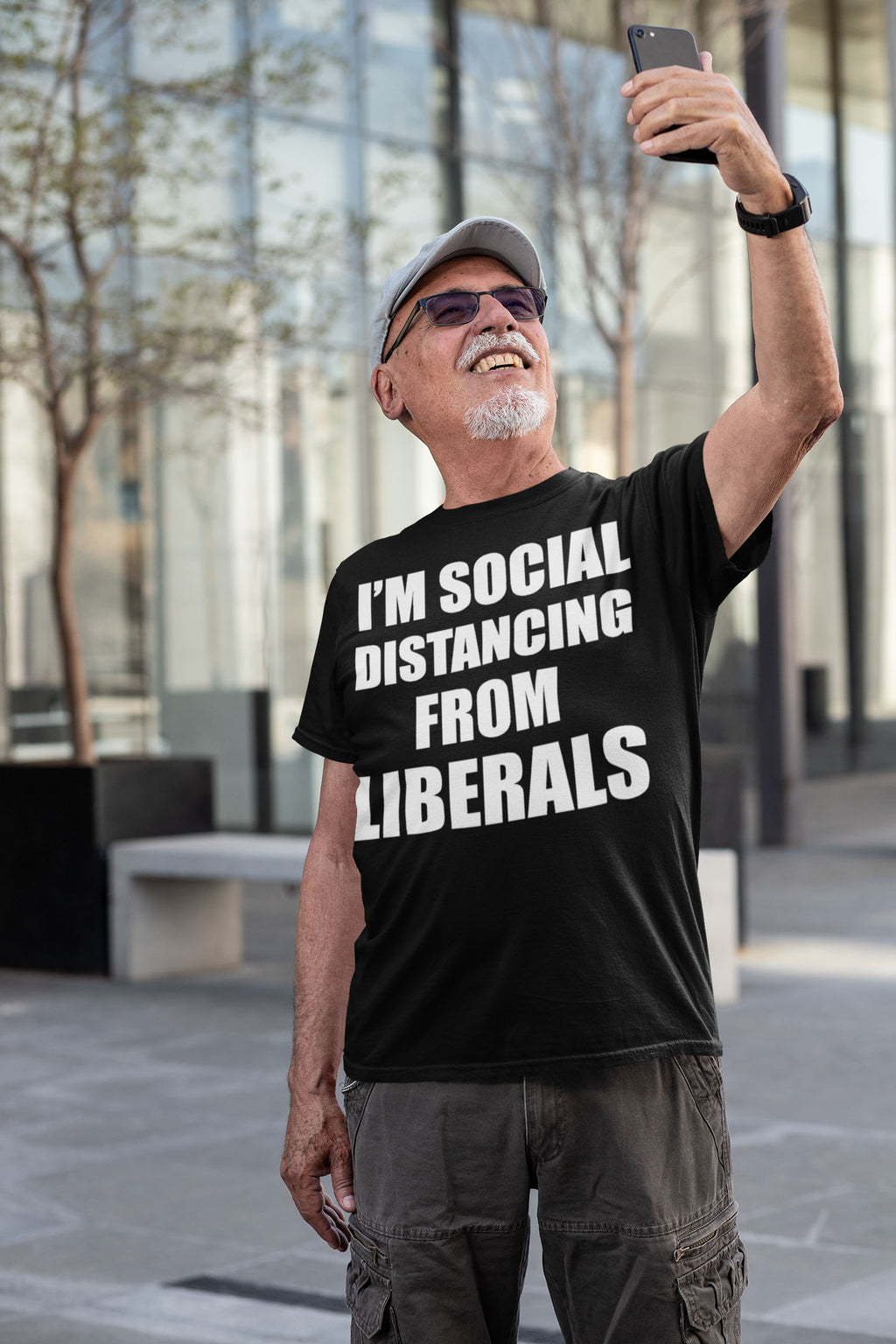 Man wearing an 'I'm Social Distancing From Liberals' shirt taking a selfie outside.