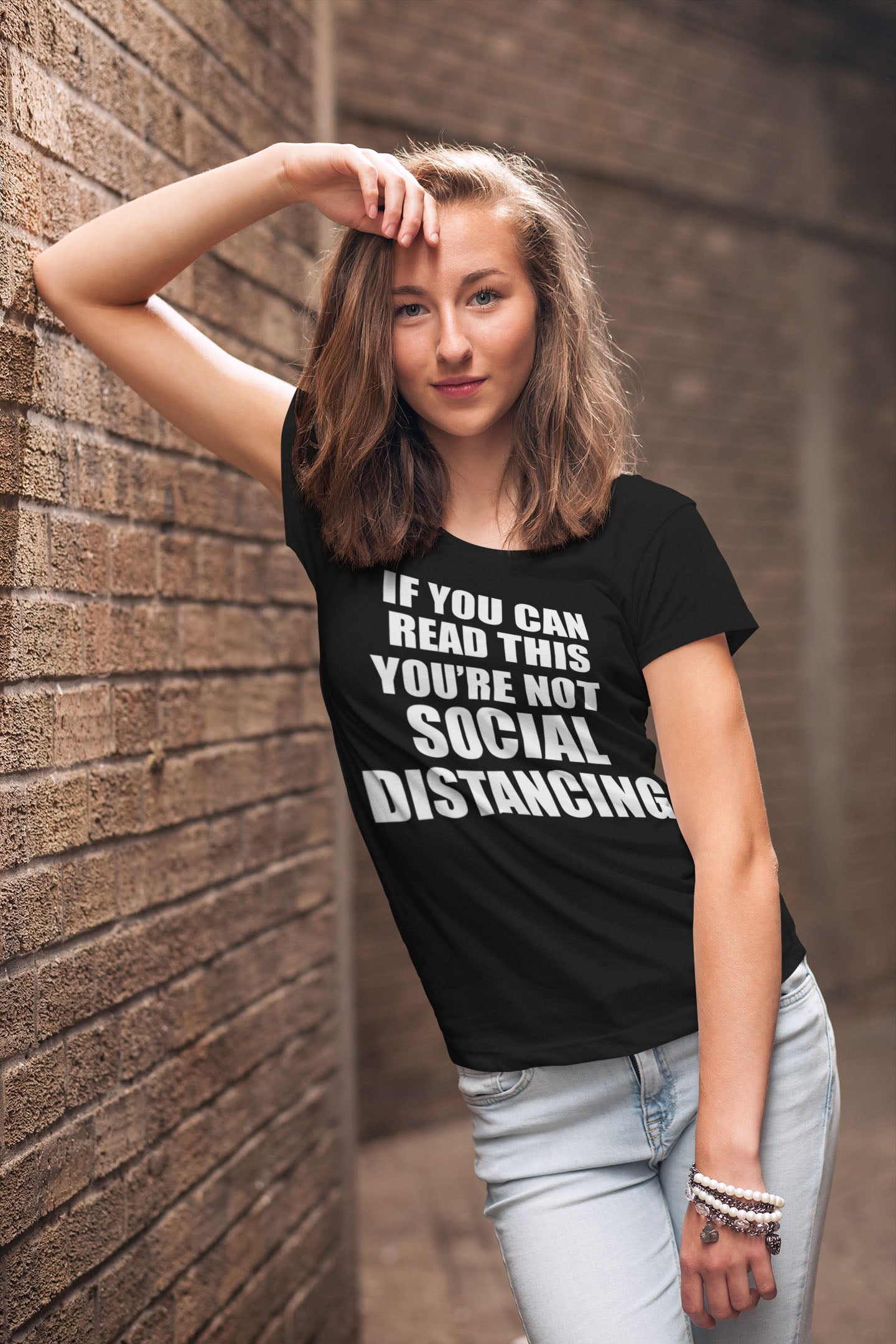 Woman wearing If You Can Read This Not Social Distancing Statement Tee in an urban setting.