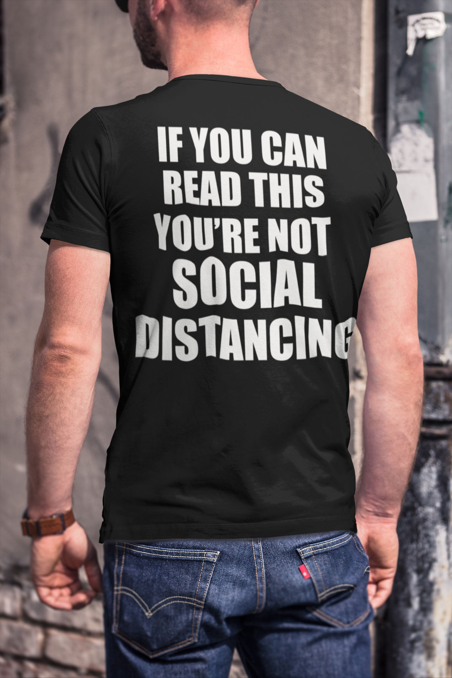 Back view of a t-shirt with the text 'If You Can Read This You're Not Social Distancing On Back' worn by a person.