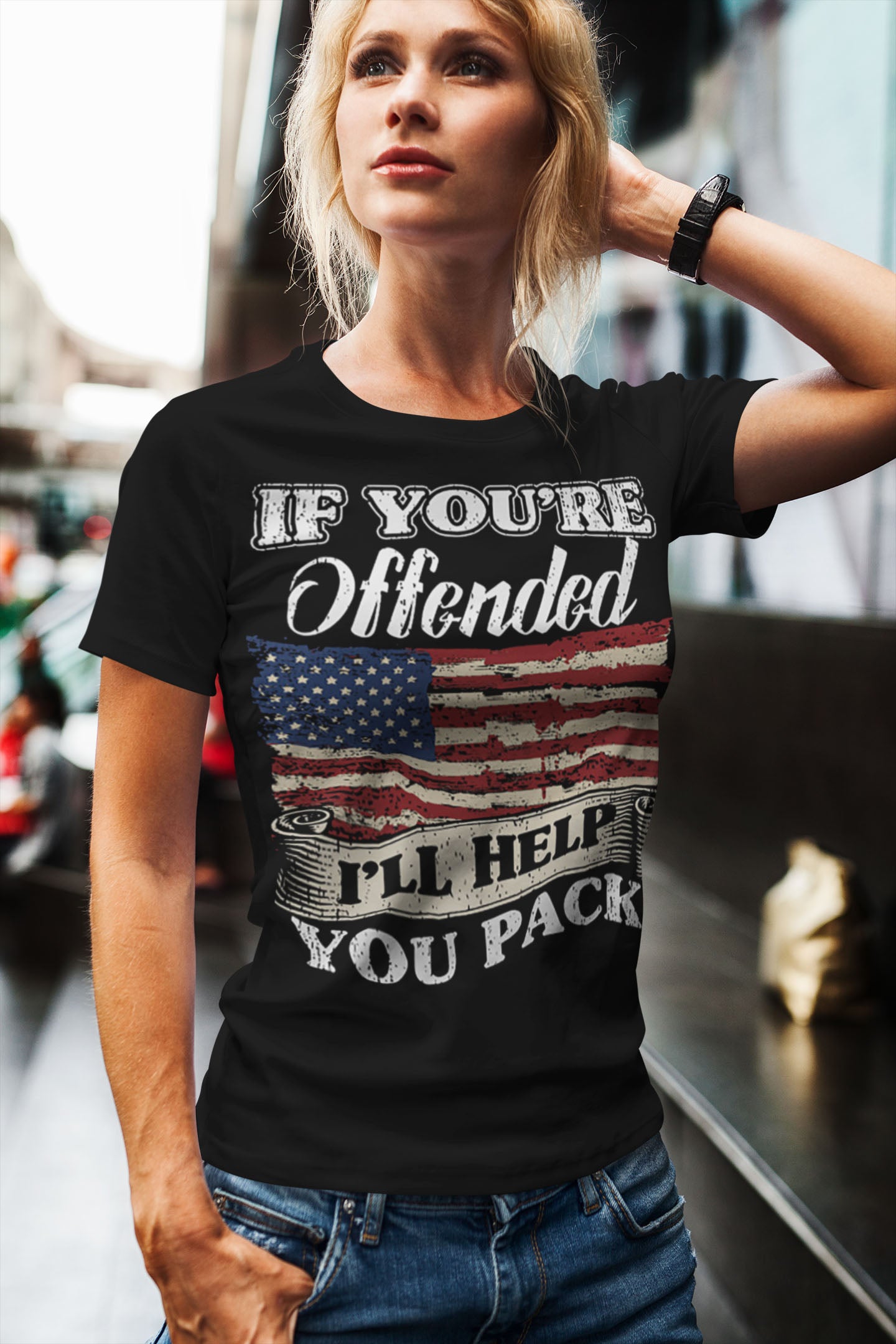 Woman wearing Bold Statement Humor Graphic Tee with an American flag design and humorous text, standing outside in casual jeans.