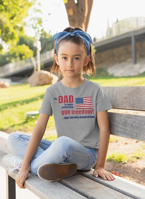 Girl wearing Dad Away Protecting Freedom Proud Of Him Graphic Tee sitting on a park bench in casual jeans and headband.