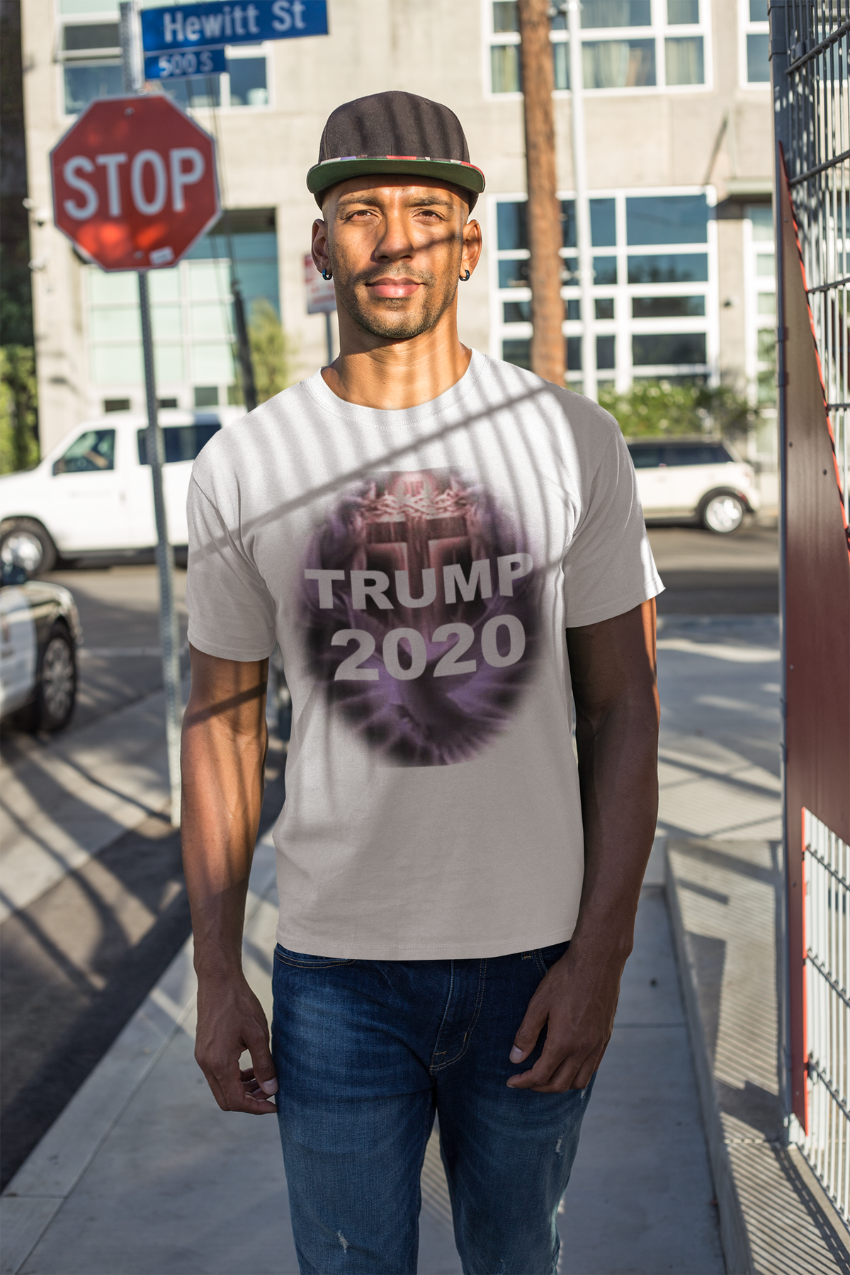 Model wearing Trump 2020 Cross & Dove Faith Shirt in urban setting with stop sign.