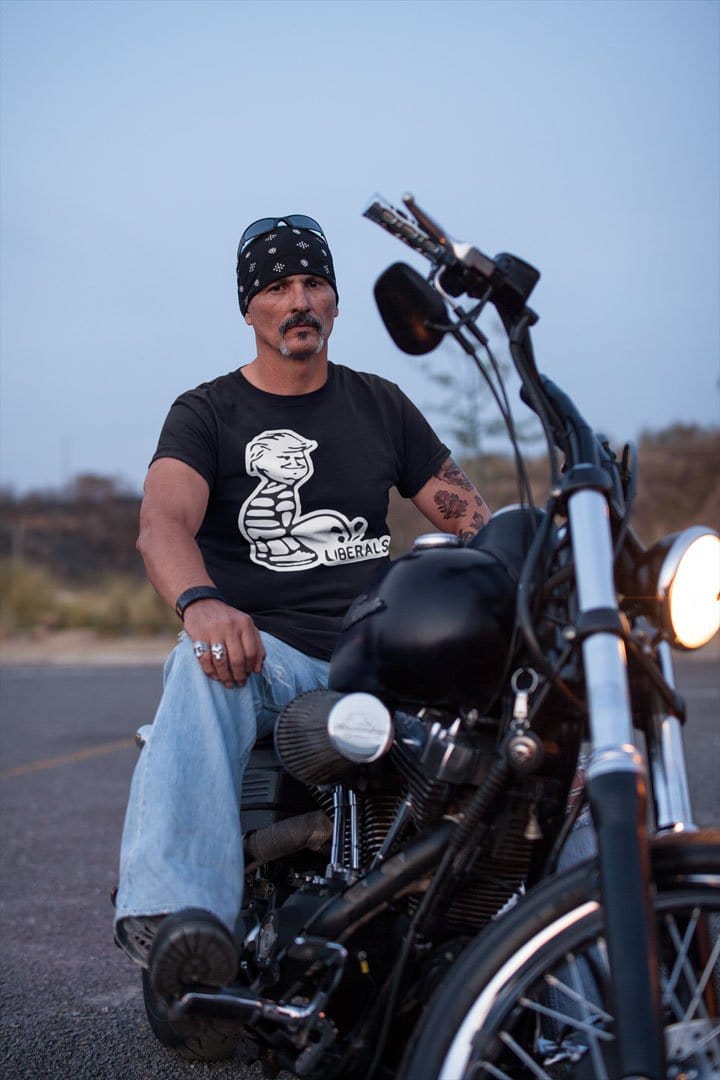 Peeing On Liberals Trump Humor Graphic Tee Shirt worn by a man on a motorcycle featuring political comedy design.