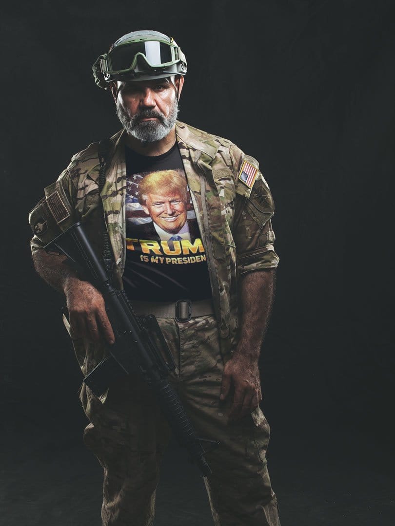 Man wearing Is My President Trump Patriotic Statement Tee Shirt under military gear, holding a gun.