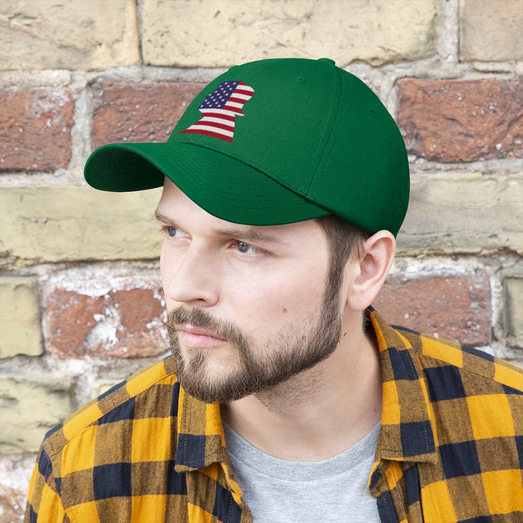 Trump American Flag SilhouetteTwill Cap worn by a man with a beard against a brick wall.
