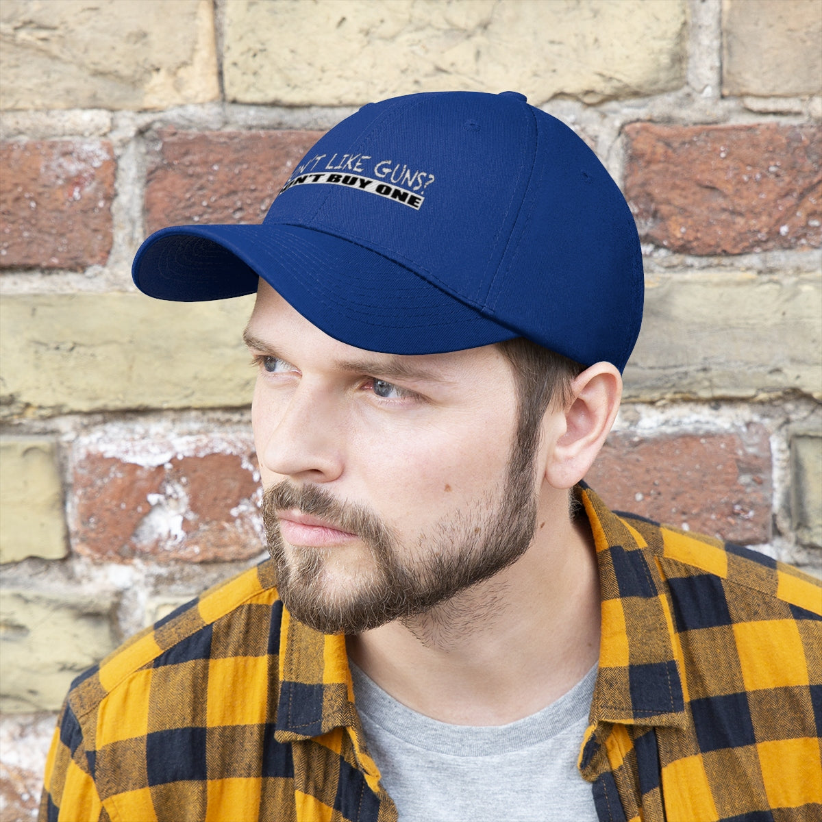 Don't Like Guns Don't Buy One Twill Cap worn by a man in front of a stone wall, showcasing a bold statement on personal liberty.