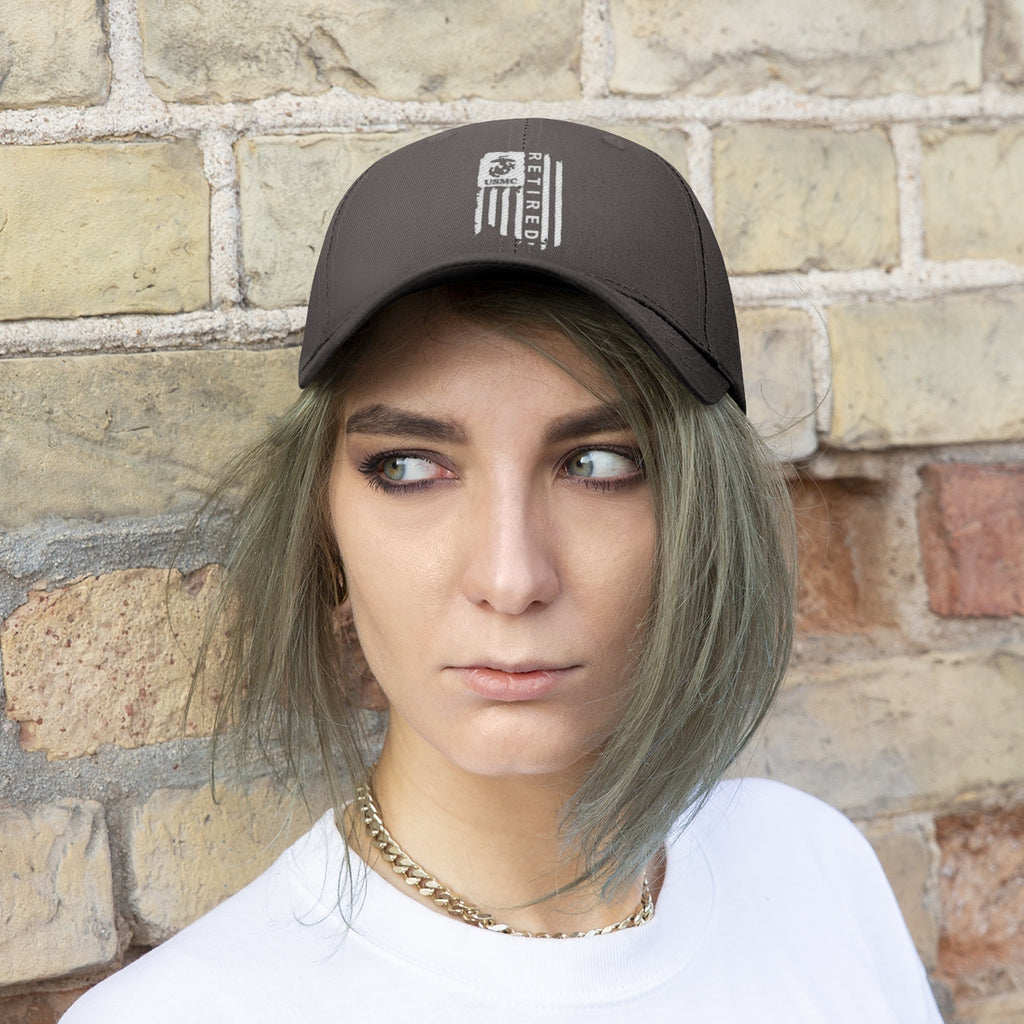 USMC Retired On Distressed American Flag Twill Cap worn by a model against a brick wall background.