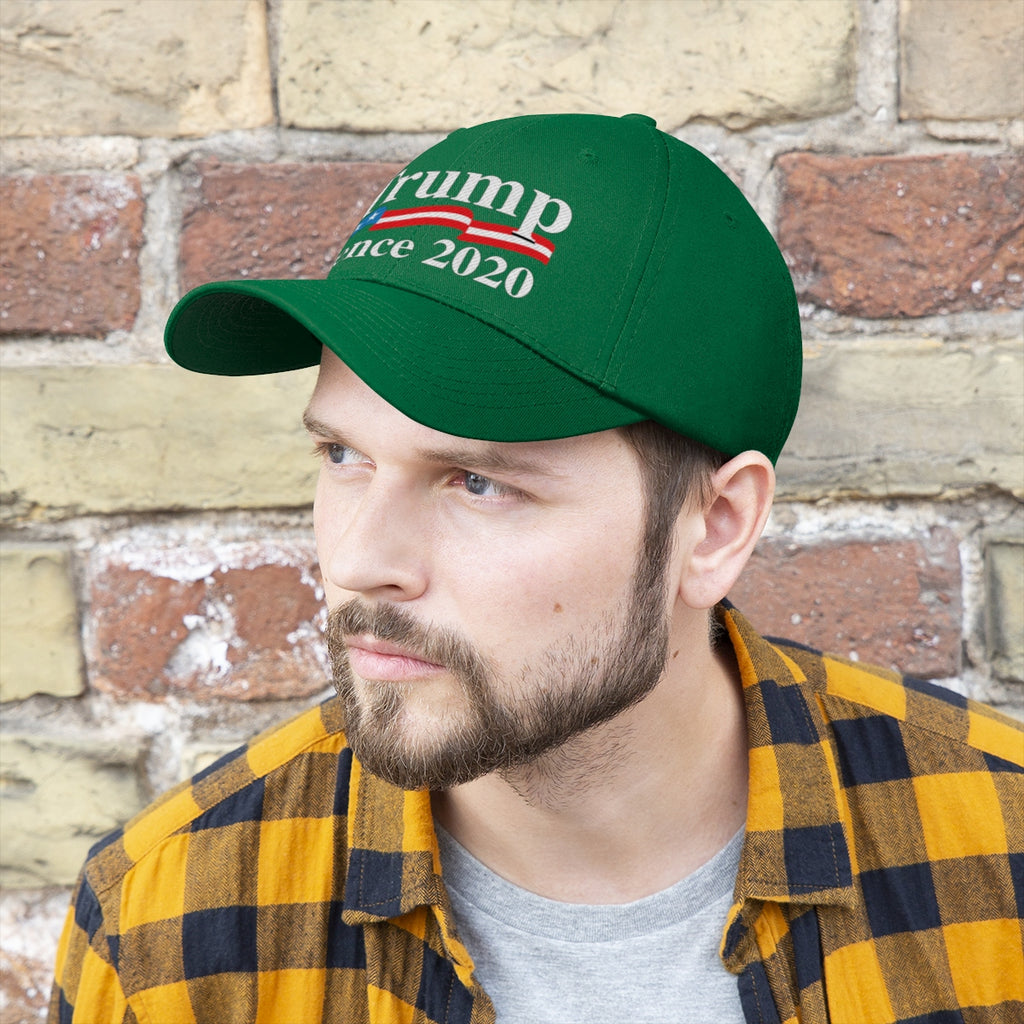 Trump Pence 2020 American Flag Twill Cap worn by a man with a beard and plaid shirt against a brick wall.
