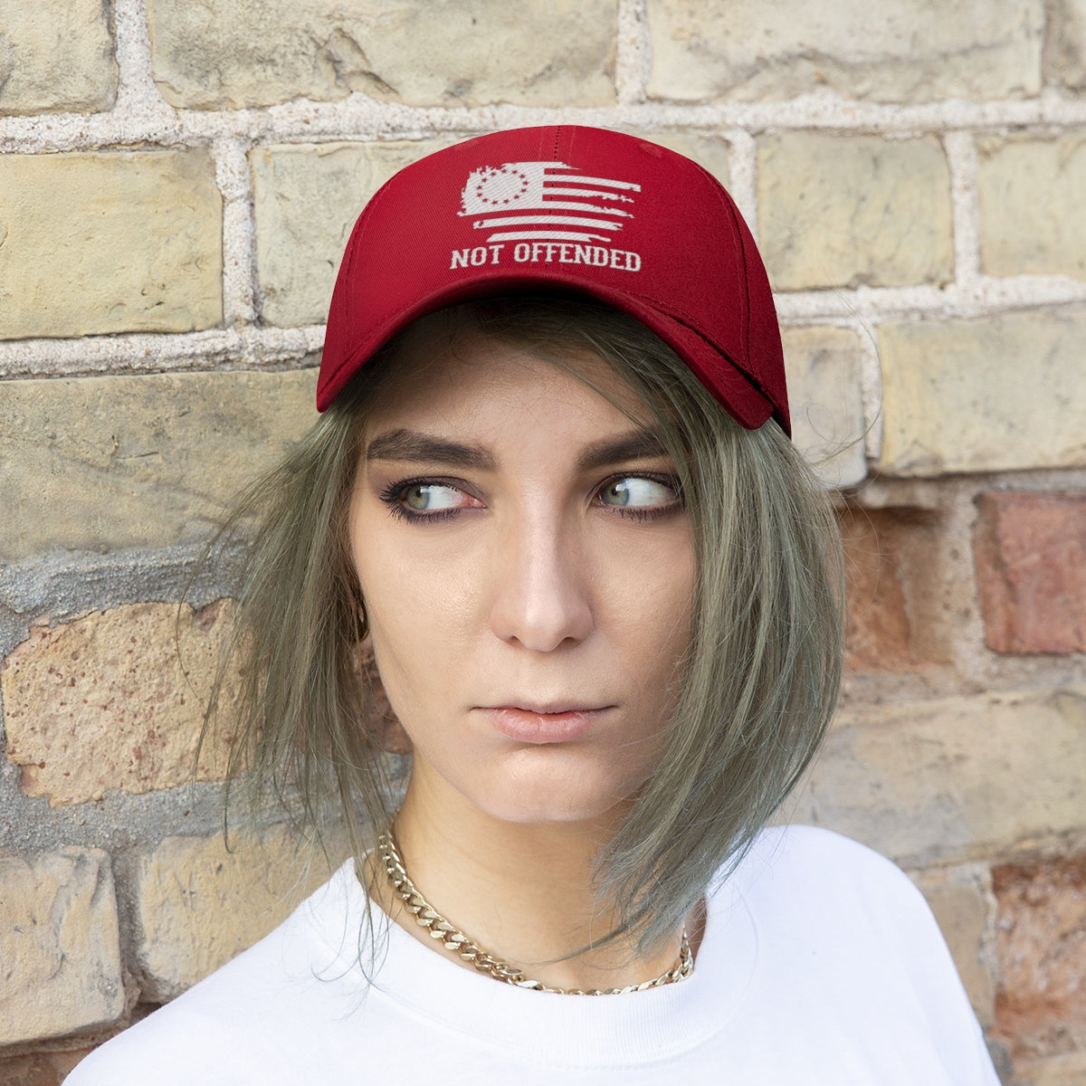 Embroidered Not Offended Adjustable Twill Cap worn by a person against a brick wall background.