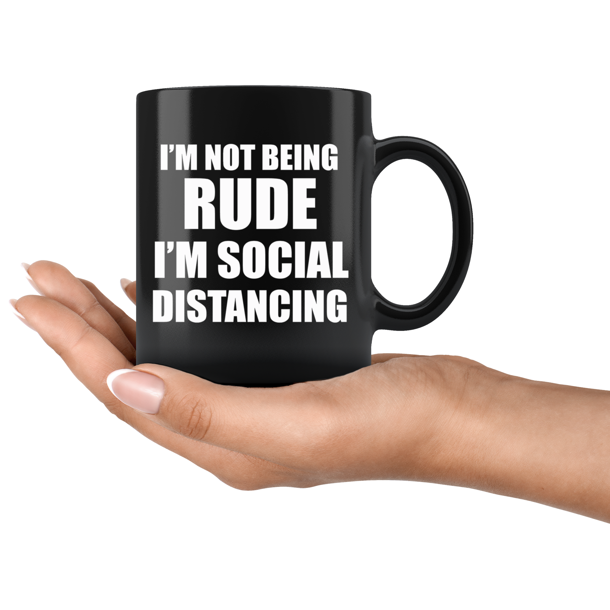Black mug with bold text "I'm Not Being Rude I'm Social Distancing" held in a hand, showcasing humorous pandemic era statement.