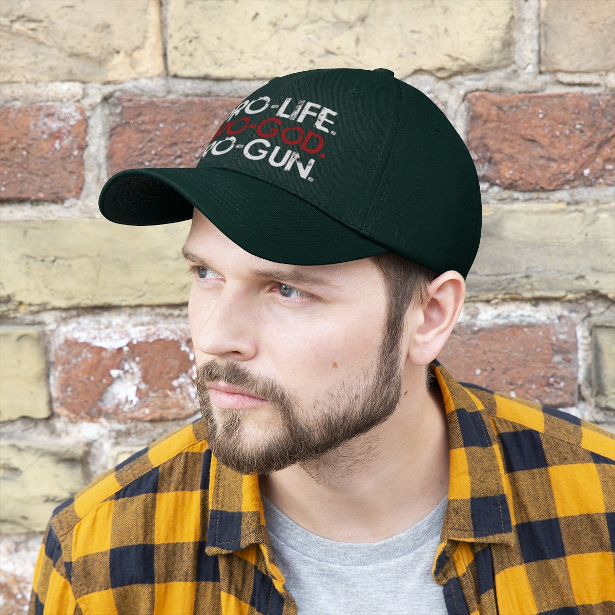 Man wearing Pro-Life Pro-God Pro-Gun Cotton Twill Cap in front of a brick wall, showcasing a definitive style.