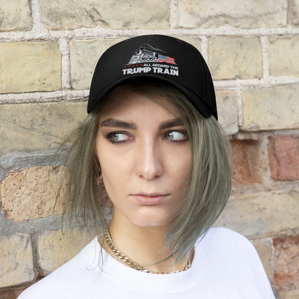 Person wearing the All Aboard The Trump Train 2020 Twill Cap against a brick wall.