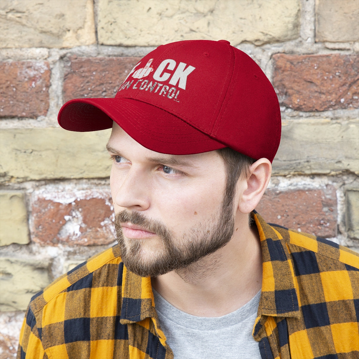 Fuck Gun Control Red Finger Twill Baseball Cap worn by a man with beard against a brick wall backdrop.