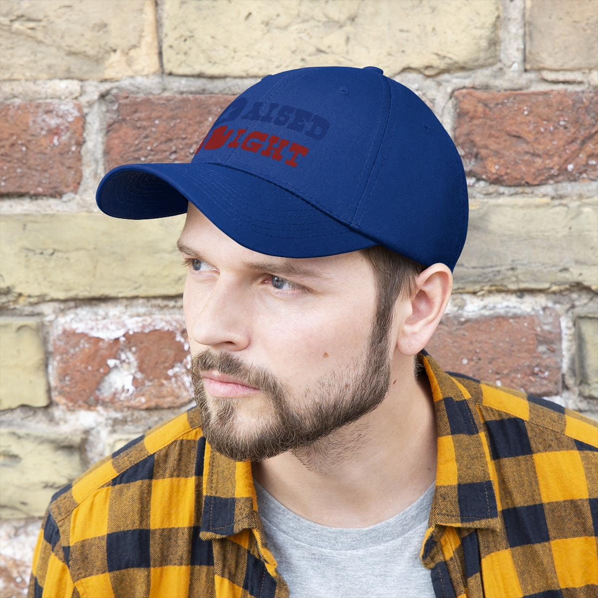 Raised Right Twill Cap Bold Values Casual Wear Cap worn by a man against a brick wall background.