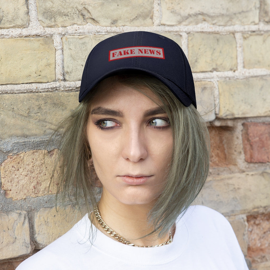 Fake News Twill Cap Bold Humor Casual Wear Hat worn by a model against a brick wall.